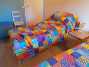 a bedroom with two beds with a colorful quilt at Olystic bed and breakfast in Seriate