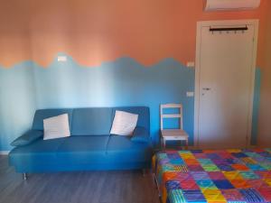 a living room with a blue couch and a chair at Olystic bed and breakfast in Seriate