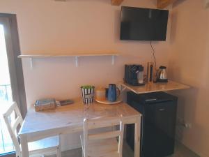 a small kitchen with a wooden table with chairs and a microwave at Olystic bed and breakfast in Seriate