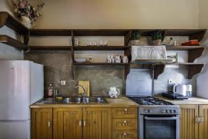 a kitchen with a sink and a stove and a refrigerator at Manoli's Light Stone House in Vathi +15 photos
