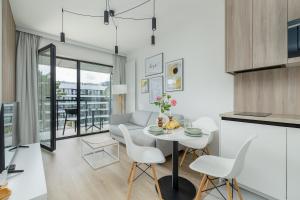 a kitchen and living room with a table and chairs at Shellter Resort Apartment by Solarento in Rogowo