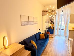 a living room with a blue couch and a table at LelleBay in Balatonlelle