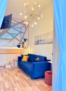 a living room with a blue couch and a bed at LelleBay in Balatonlelle