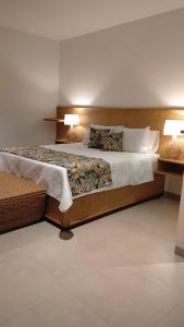 a bedroom with a large bed with two lamps at 31 Exclusive Cabin with Private Jacuzzi, Beach in Tubará +41 photos