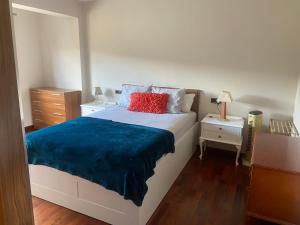 a bedroom with a bed with a blue blanket on it at Refugio de ensueño in Sabiñánigo