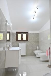 a bathroom with two sinks and two toilets at FarmVille B&B in Moliterno