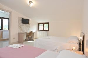 a white room with two beds and a desk at FarmVille B&B in Moliterno +2 photos