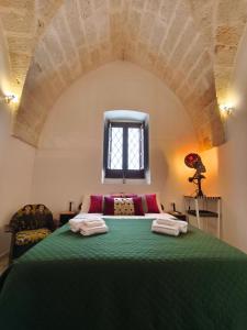 a bedroom with a green bed with a window at Chez Liart 1 in Fasano