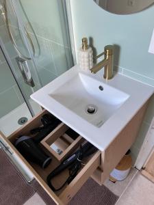 a white sink in a bathroom next to a shower at appartement de charme in Pont-Sainte-Marie +1 photo