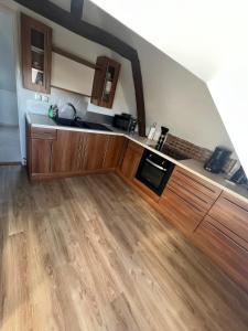 a kitchen with wooden cabinets and a wooden floor at appartement de charme in Pont-Sainte-Marie
