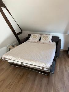 a bed with two pillows on it in a room at appartement de charme in Pont-Sainte-Marie