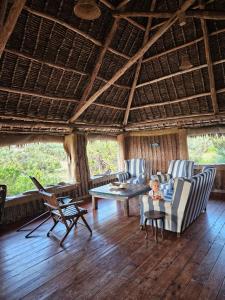 a living room with two chairs and a table at Bone Idle, Lamu Beach Home in Lamu