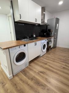 a kitchen with a sink and a washing machine at Alma in La Canyera