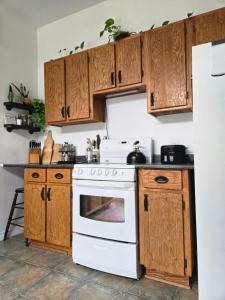 a kitchen with wooden cabinets and a white oven at Shediac Beach Suite- Pointe du Chene Wharf and Parlee Beach in Pointe-du-Chêne