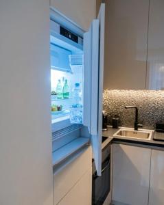 an open refrigerator with bottles of water in it at Sotto Il Sole in Surčin