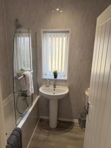 a bathroom with a sink and a window and a shower at Cosy 2 Bed By Pleasure Beach in Blackpool +4 photos