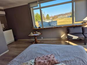 a bedroom with a bed and a large window at Ozolkungi in Turaida