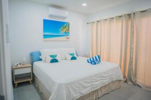 a white bedroom with a bed and a view of the beach at Chiquitos Apartments in Savaneta