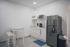 a kitchen with a stainless steel refrigerator and a table at Chiquitos Apartments in Savaneta