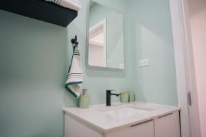 a bathroom with a white sink and a mirror at Chiquitos Apartments in Savaneta +15 photos