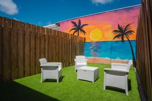 a group of chairs and tables in front of a fence at Chiquitos Apartments in Savaneta