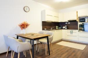 a kitchen with a dining room table and chairs at Rotunda 309 in Dunajská Streda
