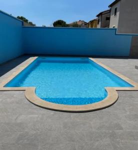 a large blue swimming pool on top of a building at Volme home in Banjole +4 photos