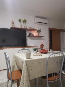 a kitchen with a table with chairs and a tv at Volme home in Banjole