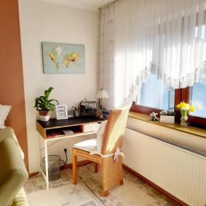 an office with a desk and a chair next to a window at Ferienwohnung " Am Dorfbrunnen" in Dienethal