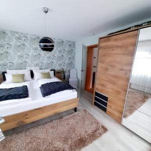 a bedroom with a bed and a sliding glass door at Ferienwohnung " Am Dorfbrunnen" in Dienethal