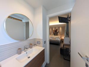 a bathroom with a sink and a mirror and a bedroom at Etna Stone Rooms in Zafferana Etnea