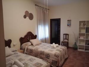 a bedroom with two beds and a chair at Los Tres Lobitos in Orgaz