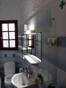 a bathroom with a sink and a toilet at Akrata Golden Beach House in Aíyira