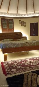 a bedroom with a bed and a rug on the floor at Om Niwas Bhunga in Bhuj
