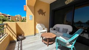 a balcony with chairs and a couch and a table at Gorgeous Third-Level Condo Princesa D-308 in Puerto Peñasco +30 photos