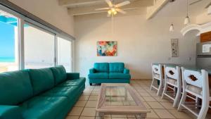 a living room with a blue couch and chairs at Charming and Cozy Beachfront Condo - Las Olas II 3 in Puerto Peñasco