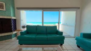 a living room with a couch and a view of the ocean at Charming and Cozy Beachfront Condo - Las Olas II 3 in Puerto Peñasco