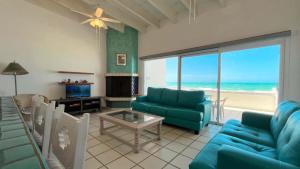 a living room with blue couches and a view of the ocean at Charming and Cozy Beachfront Condo - Las Olas II 3 in Puerto Peñasco