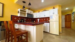 a kitchen with white cabinets and a white refrigerator at Cozy Ground Level Condo near Pool Pinacate 112 in Puerto Peñasco