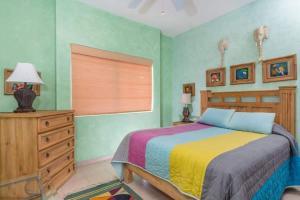 a bedroom with a bed and a dresser and a window at Serene & Warm 3rd Level Condo - Corona del Mar 302 in Puerto Peñasco