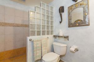 a bathroom with a toilet and a mirror at Serene & Warm 3rd Level Condo - Corona del Mar 302 in Puerto Peñasco +16 photos