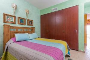 a bedroom with a bed with a colorful blanket at Serene & Warm 3rd Level Condo - Corona del Mar 302 in Puerto Peñasco