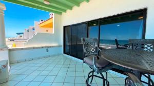 a balcony with a table and chairs and the ocean at Beautiful Beachfront Condo Las Olas II 11 in Puerto Peñasco