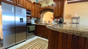a kitchen with wooden cabinets and a stainless steel refrigerator at Beautiful Beachfront Condo Las Olas II 11 in Puerto Peñasco +17 photos