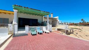 a house with a patio with two chairs and a table at Beautiful Beachfront Condo Las Olas II 11 in Puerto Peñasco