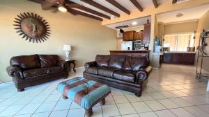 a living room with leather furniture and a kitchen at Beautiful Beachfront Condo Las Olas II 11 in Puerto Peñasco
