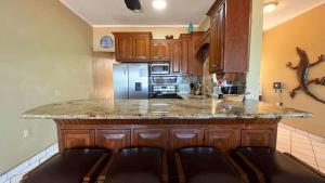a kitchen with wooden cabinets and a granite counter top at Beautiful Beachfront Condo Las Olas II 11 in Puerto Peñasco