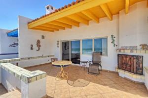 a patio with a table and chairs and a view of the ocean at Cozy Beachfront Condo Las Olas II 10 in Puerto Peñasco