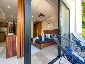 a bedroom with a bed and two chairs in a room at Casa Alba in Puerto Morelos