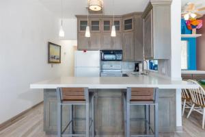 a kitchen with a large white counter and chairs at Cozy & Beautiful Beachfront Condo Las Olas II 2 in Puerto Peñasco